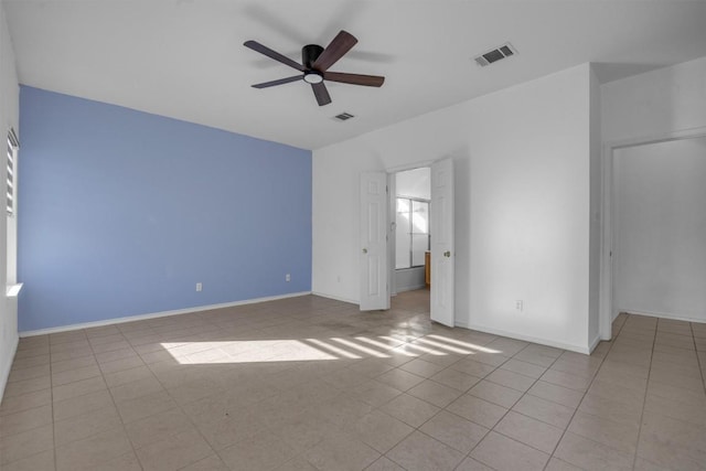 tiled spare room with ceiling fan