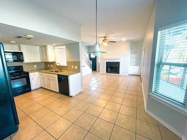 kitchen featuring white cabinetry, sink, backsplash, light tile patterned floors, and black appliances