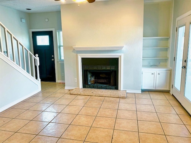 unfurnished living room featuring light tile patterned floors, built in features, a wealth of natural light, and ceiling fan