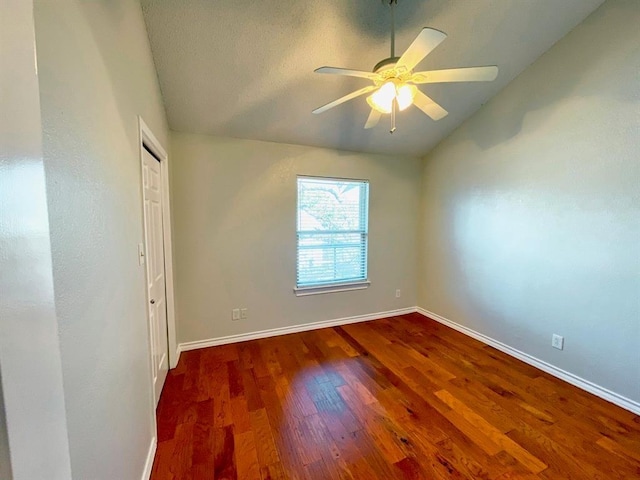 spare room with lofted ceiling, ceiling fan, and dark hardwood / wood-style floors