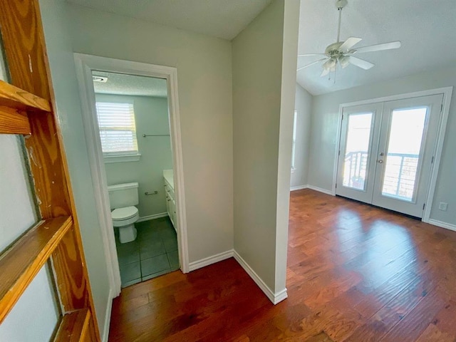 interior space with ceiling fan, a healthy amount of sunlight, toilet, and french doors