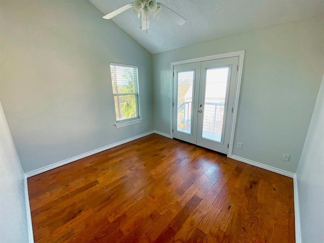 spare room featuring hardwood / wood-style flooring, ceiling fan, lofted ceiling, and french doors