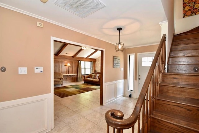 entryway featuring crown molding, plenty of natural light, and light tile patterned floors