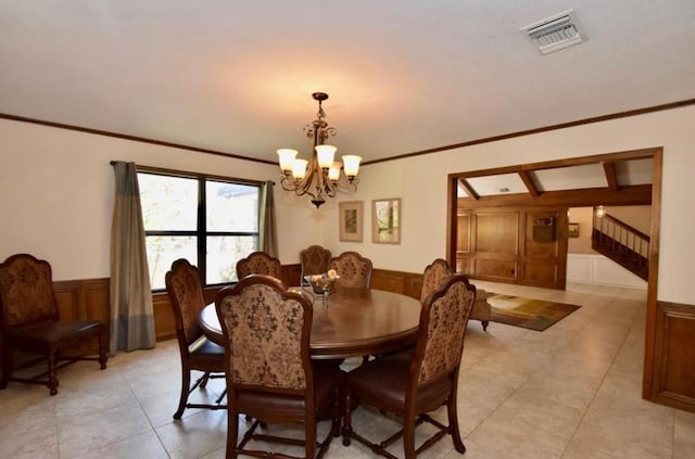 dining room with ornamental molding and a notable chandelier