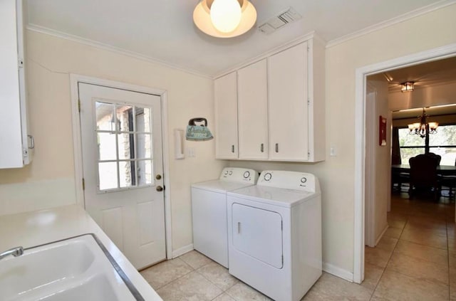 laundry area with cabinets, a chandelier, washer and clothes dryer, light tile patterned flooring, and ornamental molding