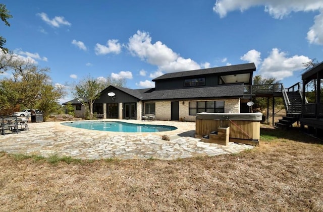 view of pool featuring a patio area, a wooden deck, and a hot tub