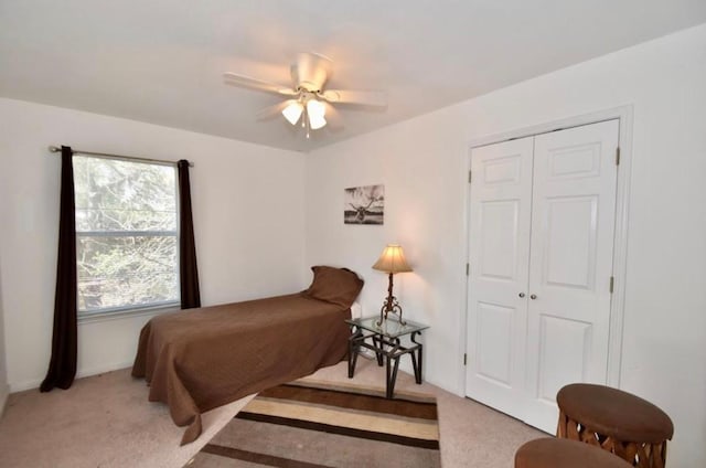 bedroom featuring light carpet, a closet, and ceiling fan