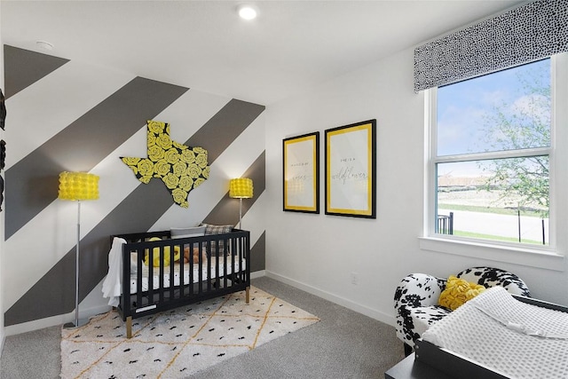 carpeted bedroom featuring a nursery area