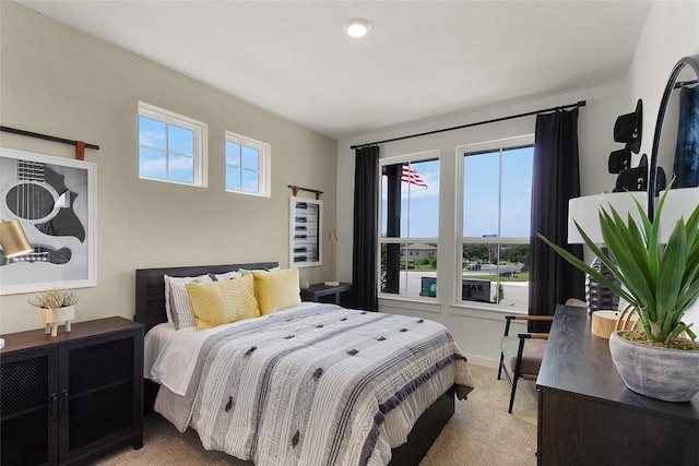 bedroom with light colored carpet and multiple windows