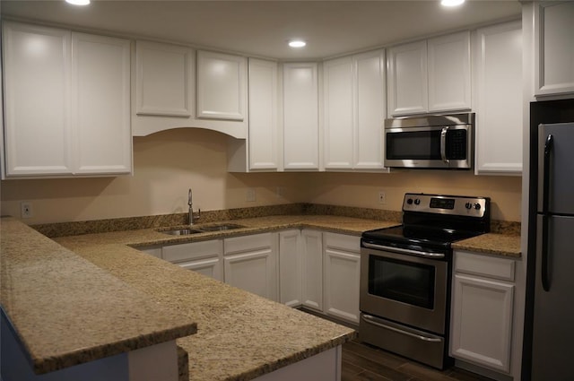 kitchen with dark hardwood / wood-style flooring, white cabinetry, sink, and appliances with stainless steel finishes