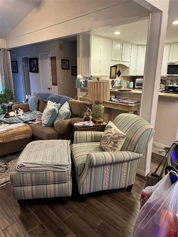 living room with a toaster, vaulted ceiling, and dark wood-style flooring