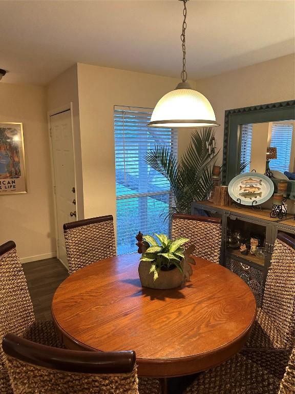 dining space featuring dark wood finished floors and baseboards