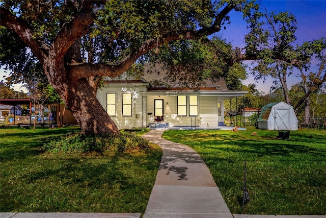 view of front of property with a yard and a storage unit