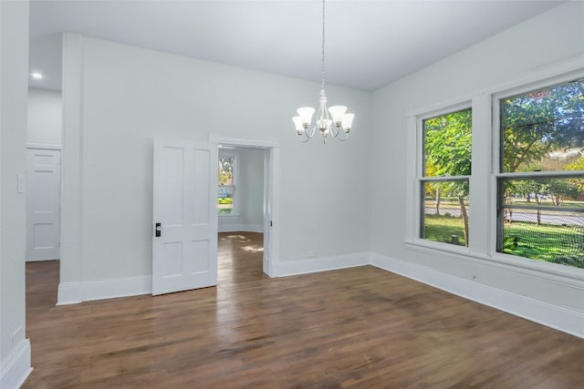 unfurnished dining area with a chandelier and dark hardwood / wood-style floors