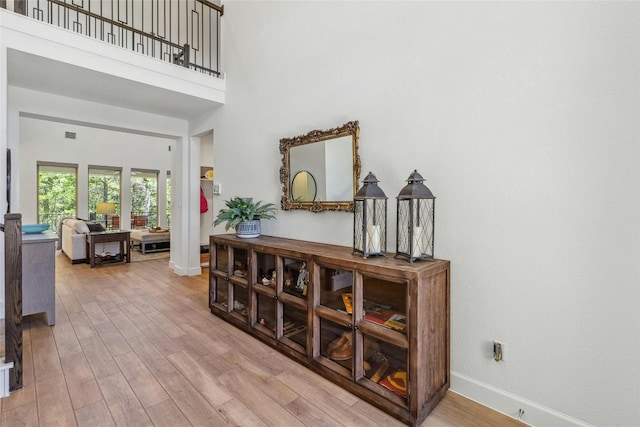 interior space with hardwood / wood-style floors and a towering ceiling