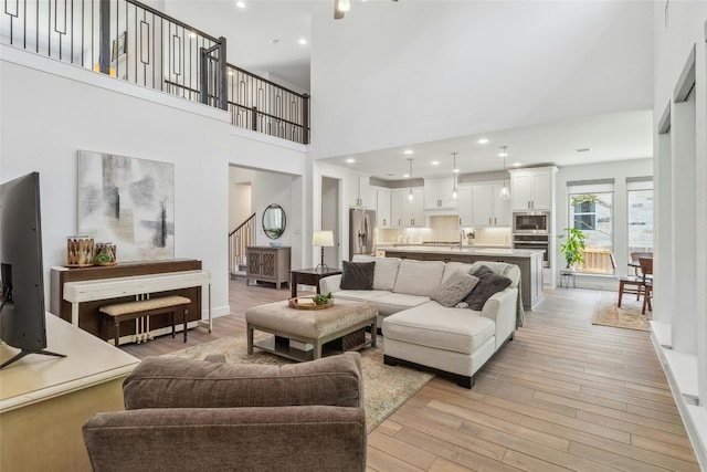 living room with light hardwood / wood-style flooring and a high ceiling