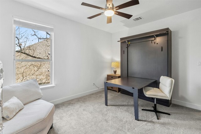 carpeted home office with ceiling fan