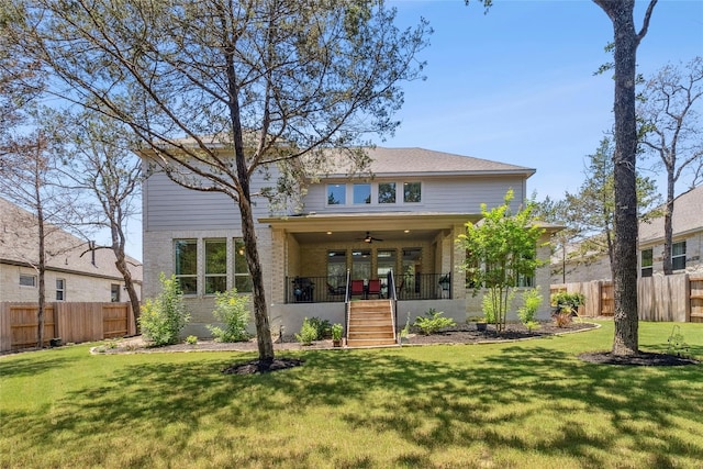 rear view of property with a lawn, ceiling fan, and a porch