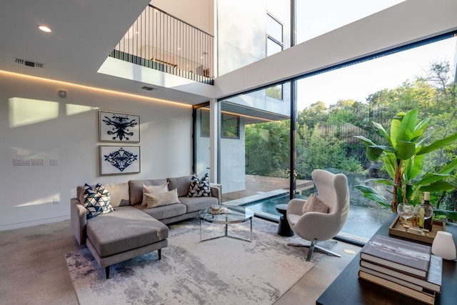 living room featuring a towering ceiling and concrete floors