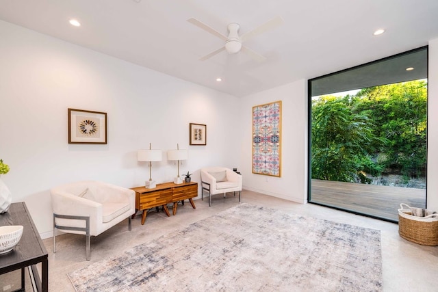 living area featuring floor to ceiling windows and ceiling fan