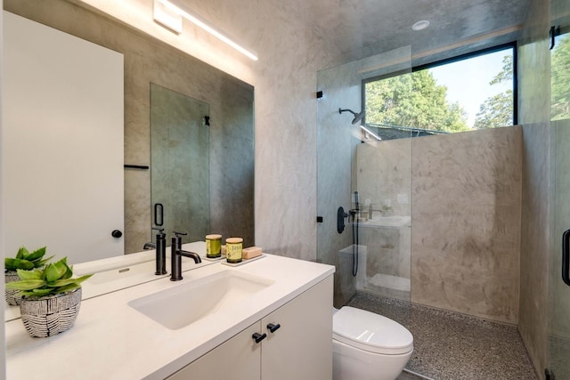 bathroom with vanity, toilet, and a shower with shower door