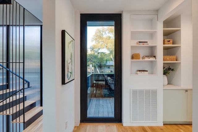 entryway featuring built in features and light hardwood / wood-style floors