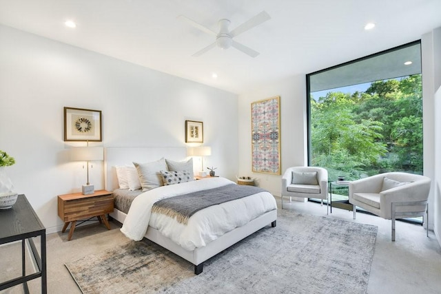 bedroom with a wall of windows and ceiling fan