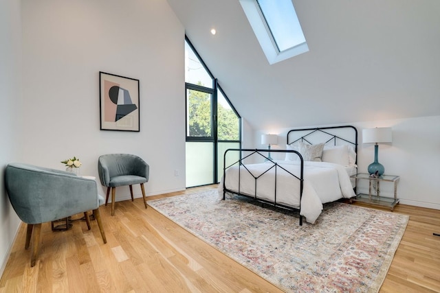 bedroom featuring hardwood / wood-style flooring and lofted ceiling with skylight