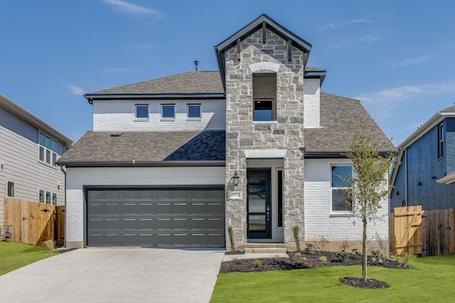 french country style house featuring stone siding, fence, driveway, and roof with shingles