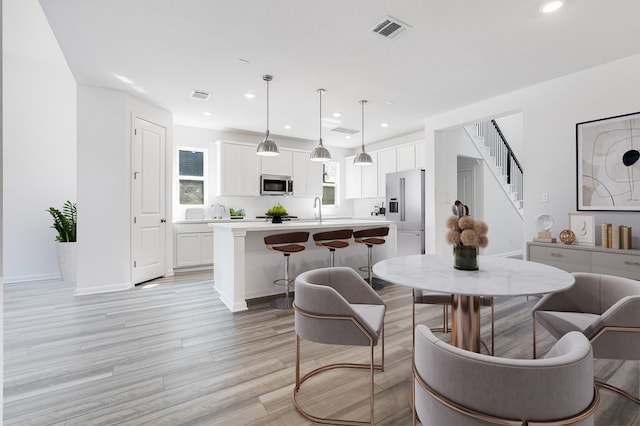 dining space with stairs, recessed lighting, light wood-style floors, and visible vents