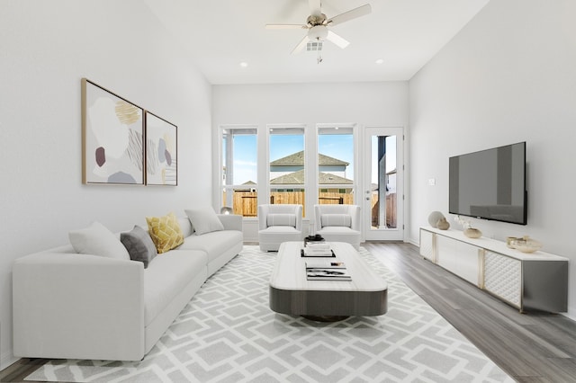 living room with a ceiling fan, recessed lighting, and wood finished floors