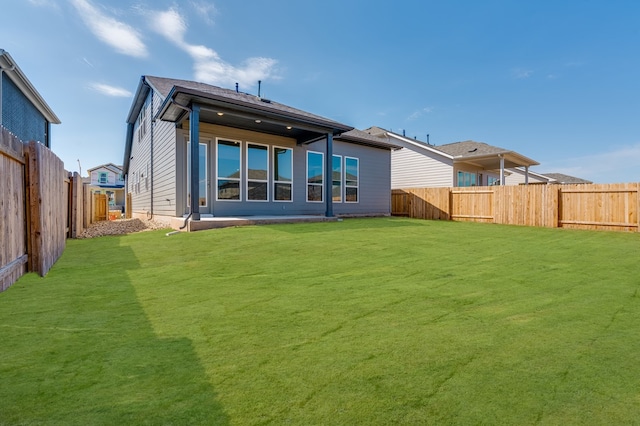 back of house featuring a yard and a fenced backyard