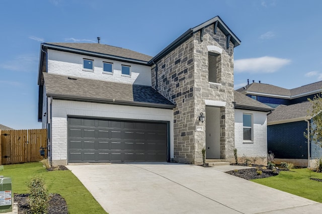 view of front facade with a garage, a shingled roof, concrete driveway, and fence