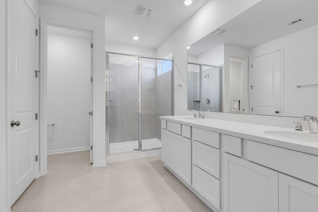 bathroom featuring a shower stall, double vanity, visible vents, and a sink