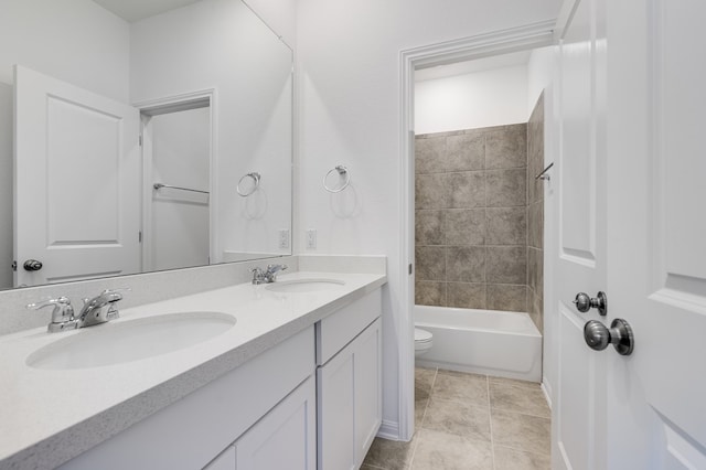 full bathroom featuring double vanity, tile patterned floors, toilet, and a sink