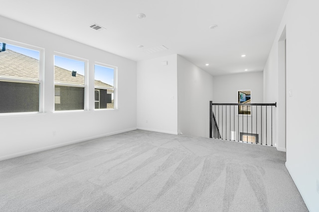 carpeted spare room featuring visible vents, recessed lighting, and baseboards