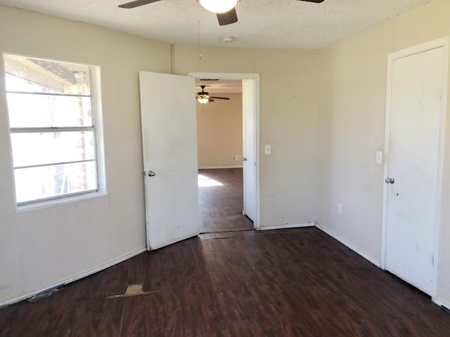 empty room featuring a textured ceiling and dark wood-type flooring