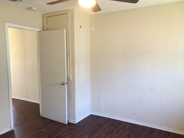 interior space with a textured ceiling, ceiling fan, and dark wood-type flooring