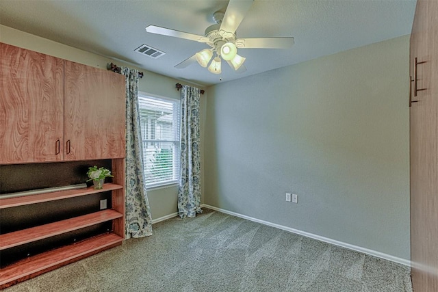 carpeted spare room with ceiling fan