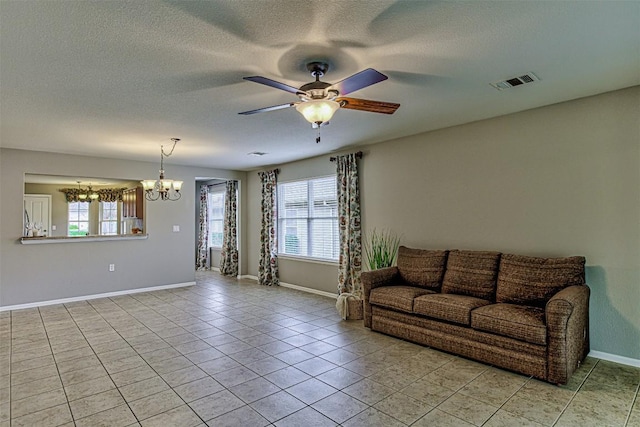 tiled living room with ceiling fan with notable chandelier