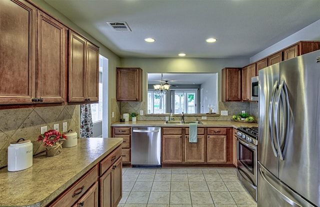 kitchen featuring sink, ceiling fan, decorative backsplash, light tile patterned floors, and stainless steel appliances