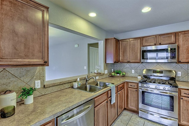 kitchen featuring decorative backsplash, sink, light tile patterned flooring, and stainless steel appliances