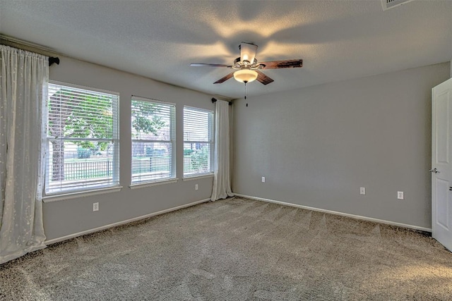 spare room featuring a textured ceiling, carpet floors, and ceiling fan