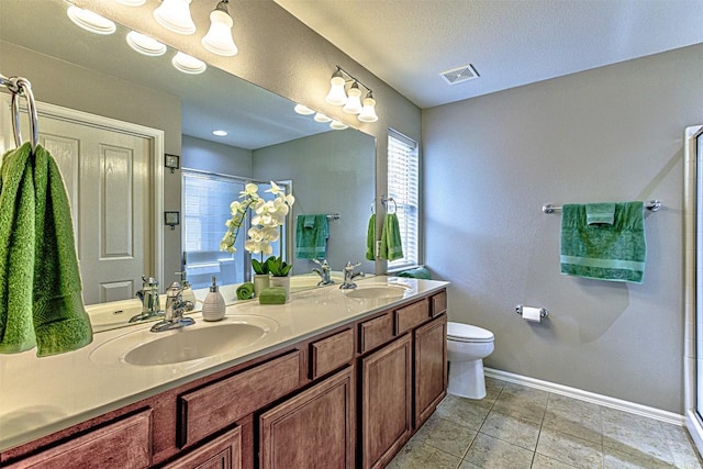 bathroom featuring tile patterned floors, vanity, toilet, and an enclosed shower