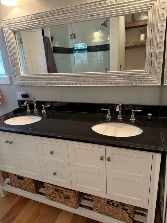 bathroom featuring a shower with door, vanity, and hardwood / wood-style flooring