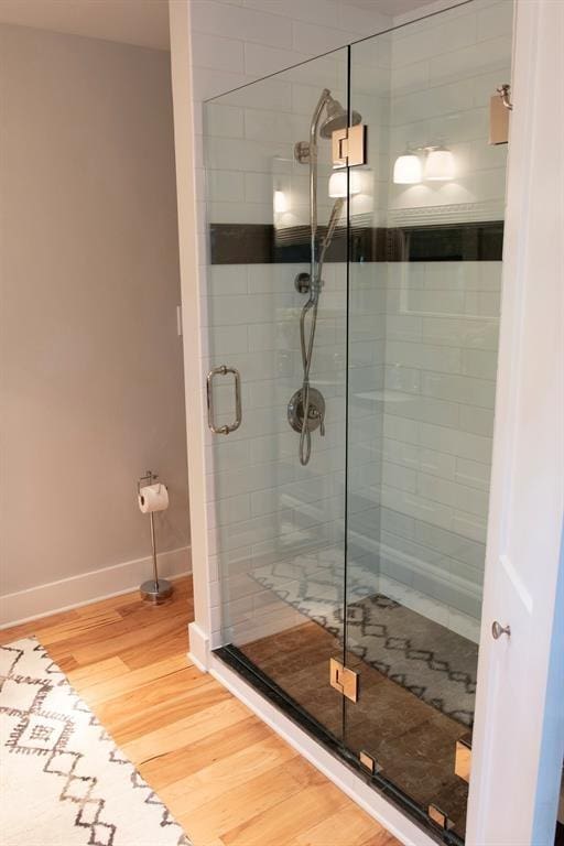 bathroom with hardwood / wood-style floors and a shower with door