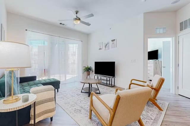 living room with ceiling fan and light wood-type flooring