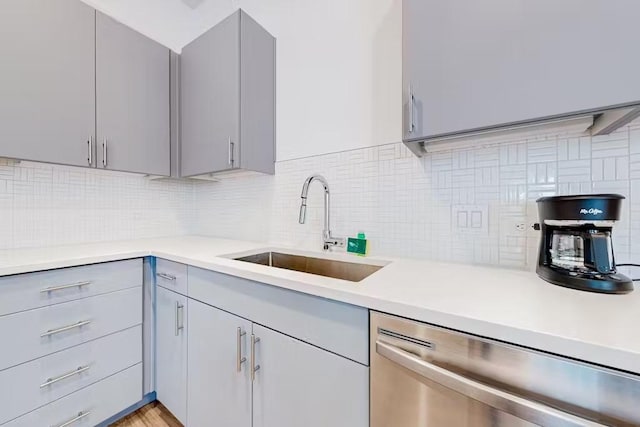 kitchen with dishwasher, decorative backsplash, gray cabinetry, and sink