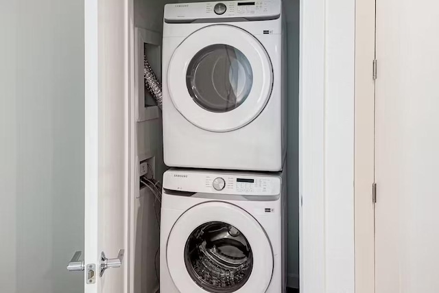 laundry room with stacked washing maching and dryer