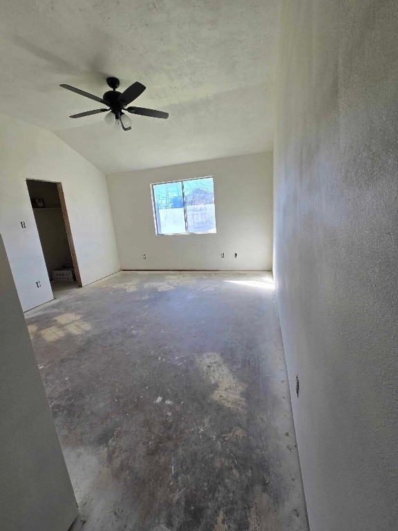 unfurnished room with ceiling fan and vaulted ceiling